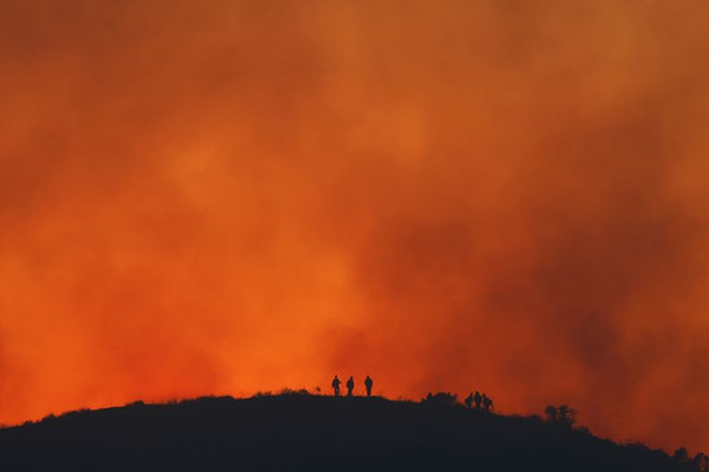 ARCHIVO – Las siluetas de varios bomberos en medio de una operación para controlar el incendio Sandy, el 19 de mayo de 2026, en Simi Valley, Calif. (AP Foto/Caroline Brehman, Archivi)