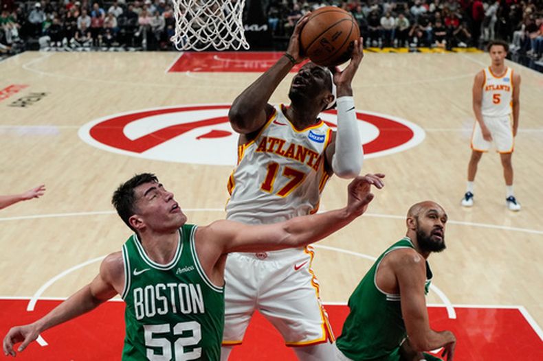 Onyeka Okongwu (17), de los Hawks de Atlanta, encesta frente a Luka Garza (52), de los Celtics de Boston, en la primera mitad del juego de baloncesto de la NBA, el lunes 30 de marzo de 2026, en Atlanta. (AP Foto/Mike Stewart)