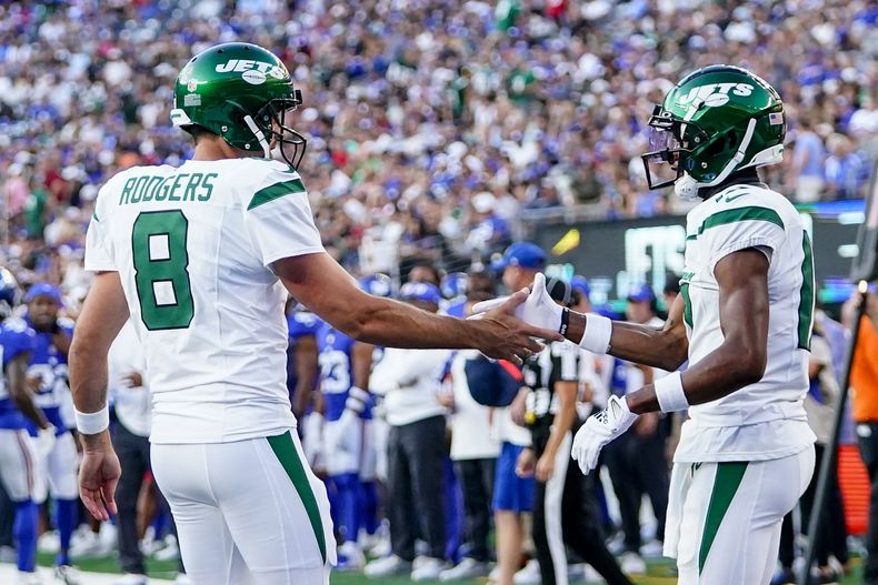 Aaron Rodgers (8), quarterback de los Jets de Nueva York, felicita al wide receiver Garrett Wilson (17) después de una recepción de touchdown de Wilson en la primera mitad del juego de pretemporada de la NFL en contra de los Giants de Nueva York, el sábado 26 de agosto de 2023, en East Rutherford, Nueva Jersey. (AP Foto/Frank Franklin II)