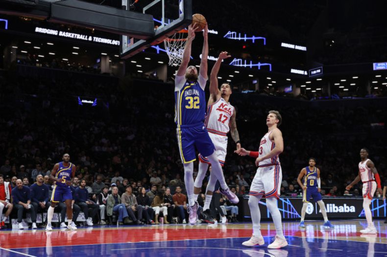 Jay Huff (32), de los Pacers de Indiana, se alza para encestar frente a Michael Porter Jr. (17), de los Nets de Brooklyn, durante la primera mitad del juego de baloncesto de la NBA, el domingo 25 de octubre de 2026, en Nueva York. (AP Foto/Pamela Smith)