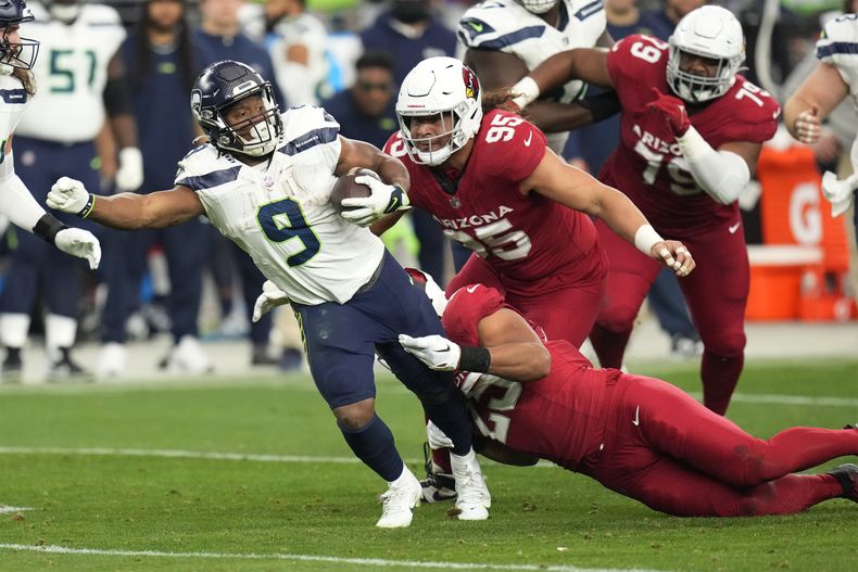 El corredor de los Seahawks de Seattle Kenneth Walker III detenido por el linebacker de los Cardinals de Arizona Zaven Collins el domingo 7 de enero del 2024. (AP Foto/Ross D. Franklin)