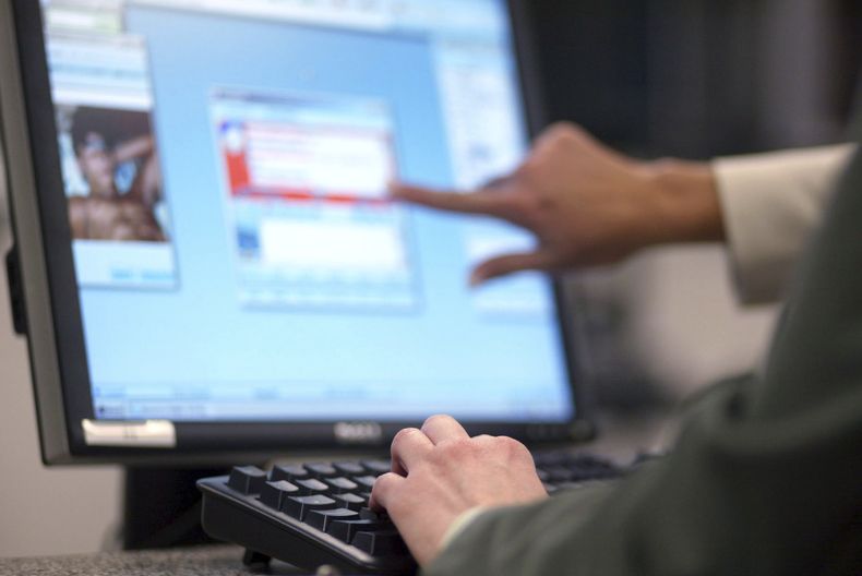Agentes del FBI examinan fotografías en internet para vigilar que no haya imágenes sexuales de menores, el 4 de mayo de 2006, en Calverton, Maryland. (Foto AP/Matt Houston)