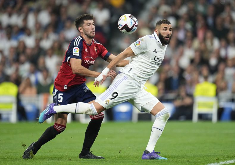 ARCHIVO - Foto del 2 de octubre del 2022, David García del Osasuna pelea por el balón con Karim Benzema del Real Madrid en el encuentro de liga en el Estadio Santiago Bernabeu. El viernes 5 de mayo del 2023, Real Madrid busca recuperar la senda del triunfo para la final de la Copa del Rey el sábado frente al Osasuna. (AP Foto/Manu Fernandez, Archivo)