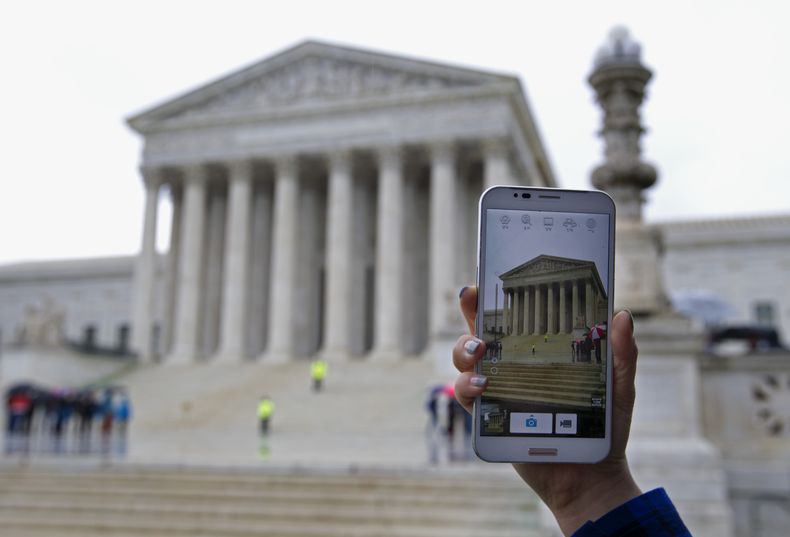 Una persona toma fotos con su tel&eacute;fono m&oacute;vil frente a la Corte Suprema en Washington el martes 29 de abril de 2014 durante una audiencia. La Corte Suprema estudia si la polic&iacute;a puede registrar los tel&eacute;fonos celualres de las per