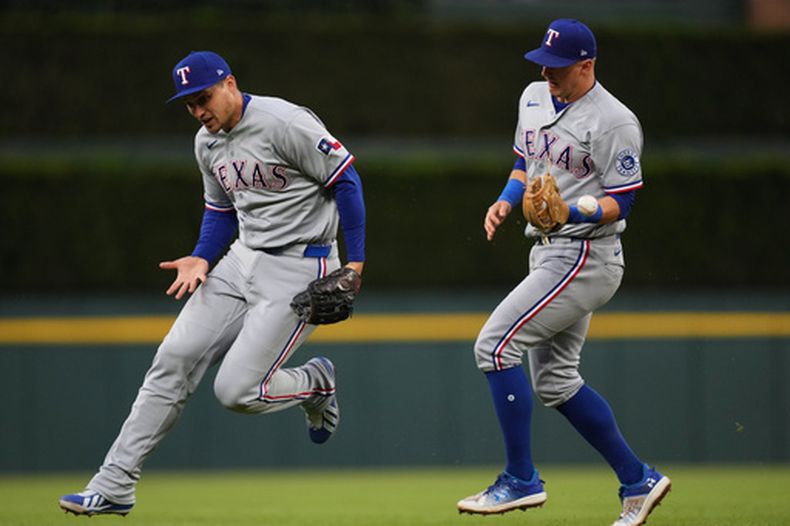 Josh Jung, izquierda, de los Rangers de Texas, se le escapa un batazo de Riley Greene, de los Tigres de Detroit, mientas que Corey Seager, derecha, observa y se ve sorprendido por la pelota, durante la cuarta entrada del juego de béisbol de Grandes Ligas, el viernes |1 de mayo de 2026, en Detroit. (AP Foto/Paul Sancya)