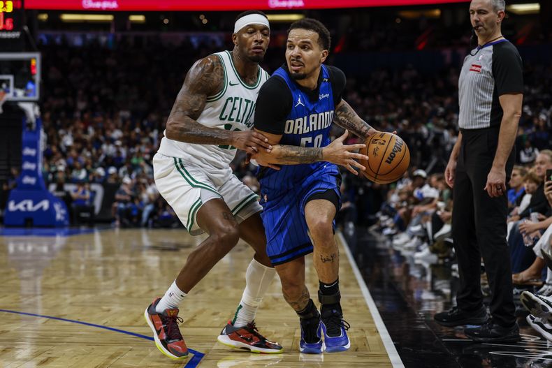 Cole Anthony, del Magic de Orlando, elude a Torrey Craig, de los Celtics de Boston, en el encuentro del miércoles 9 de abril de 2025 (AP Foto/Kevin Kolczynski)