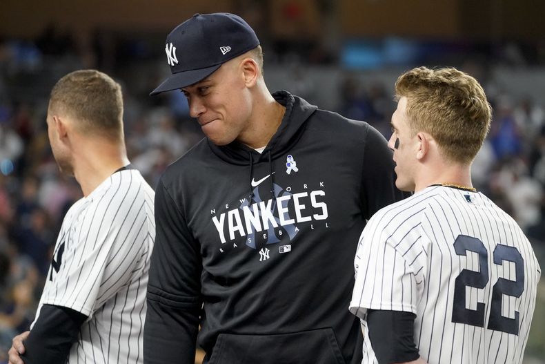 Aaron Judge, centro, jardinero de los Yanquis de Nueva York, platica con Harrison Bader (22) durante la séptima entrada del juego de béisbol en contra de los Marineros de Seattle, el martes 20 de junio de 2023, en Nueva York. (AP Foto/John Minchillo)