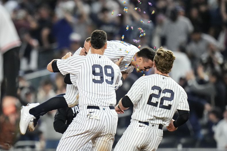 Anthony Volpe, de los Yanquis de Nueva York, festeja con sus compañeros Aaron Judge (99) y Harrison Bader (22), tras la victoria sobre los Orioles de Baltimore, el martes 23 de mayo de 2023 (AP Foto/Frank Franklin II)