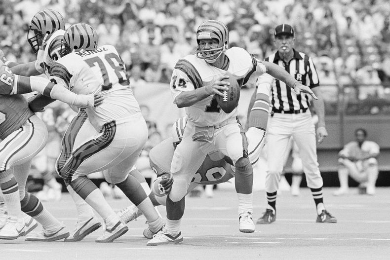 ARCHIVO - Ken Anderson, quarterback de los Bengals de Cincinnati, se escapa del pocket y de las manos de un defensa de los Oilers de Houston durante el cuarto cuarto de un juego de fútbol americano de la NFL en Cincinnati, el 13 de septiembre de 1982. (AP Photo/Ed Reinke, Archivo)