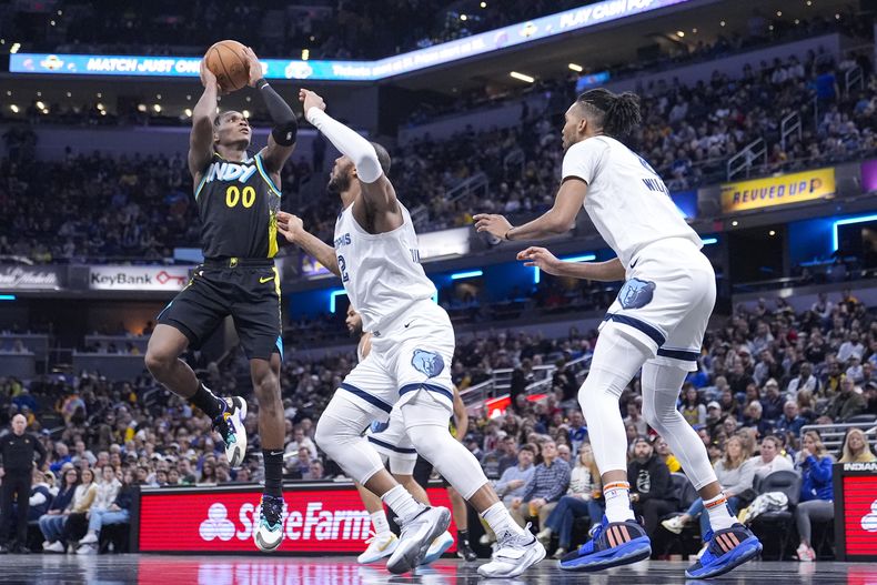 El base de los Pacers de Indiana Bennedict Mathurin lanza el balón sobre el alero de los Grizzlies de Memphis Xavier Tillman en el encuentro de la NBA el domingo 28 de enero del 2024. (AP Foto/Michael Conroy)