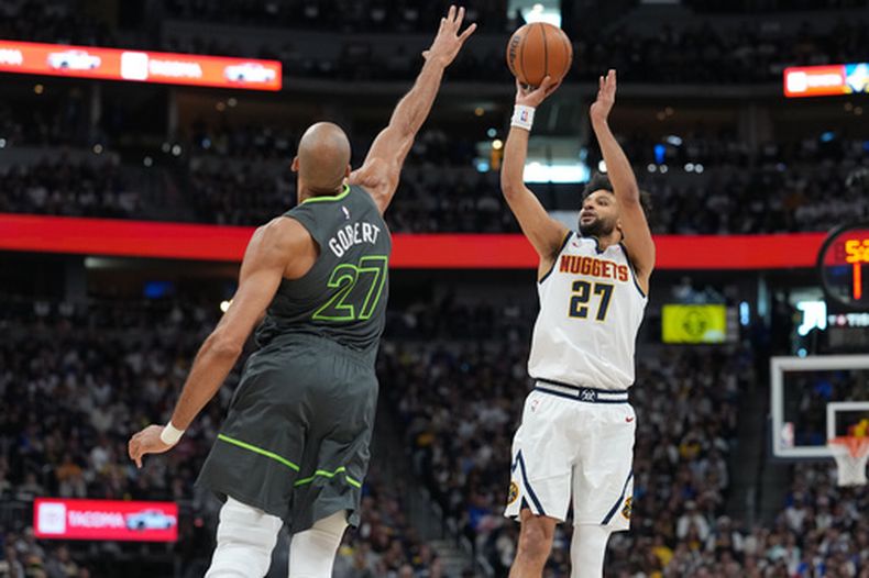 Jamal Murray de los Nuggets de Denver lanza el balón sobre el pívot de los Timberwolves de Minnesota Rudy Gobert en el primer juego de la serie de primera ronda de la postemporada el sábado 18 de abril del 2026. (AP Foto/David Zalubowski)
