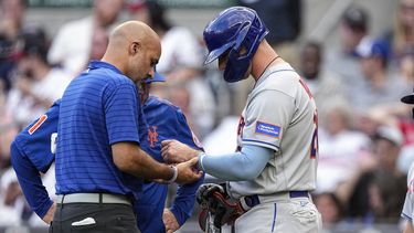 Un miembro del personal médico de los Mets de Nueva York revisa la muñeca del primera base Pete Alonso, quien se llevó un pelotazo el miércoles 7 de junio de 2023, en un duelo ante los Bravos de Atlanta (AP Foto/John Bazemore)