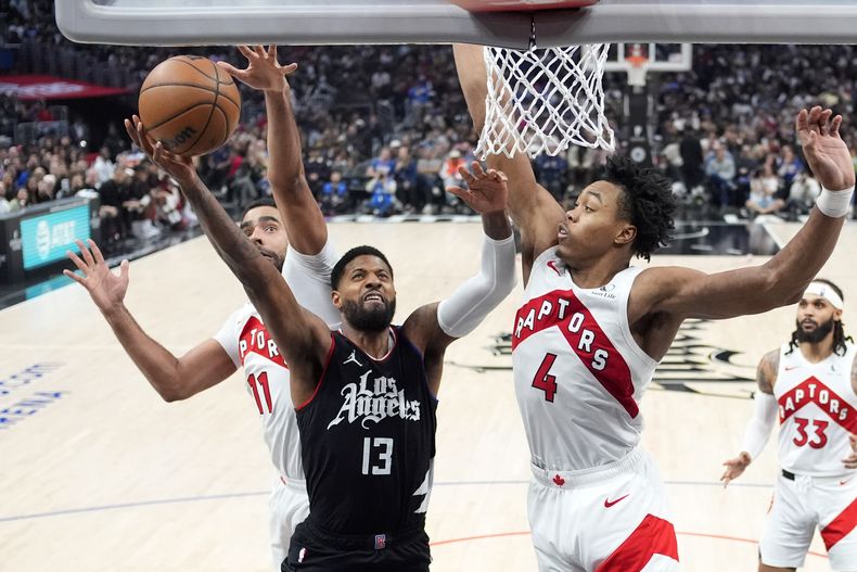 Paul George, alero de los Clippers de Los Ángeles, dispara frente a Jontay Porter, de los Raptors de Toronto, el miércoles 10 de enero de 2024 (AP Foto/Mark J. Terrill)