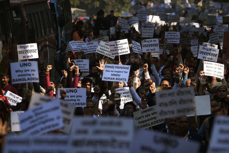 Gente corea lemas contra ataques reportados contra hindúes y otras minorías en Bangladesh, durante una protesta cerca de la misión diplomática de Bangladesh en Nueva Delhi, India, el martes 10 de diciembre de 2024. (AP Foto/Manish Swarup)
