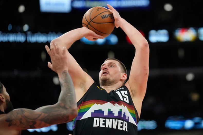 Nikola Jokic, de los Nuggets de Denver, envía un pase frente a Nick Richards, de los Bulls de Chicago, en el partido del sábado 7 de febrero de 2026 (AP Foto/Erin Hooley)