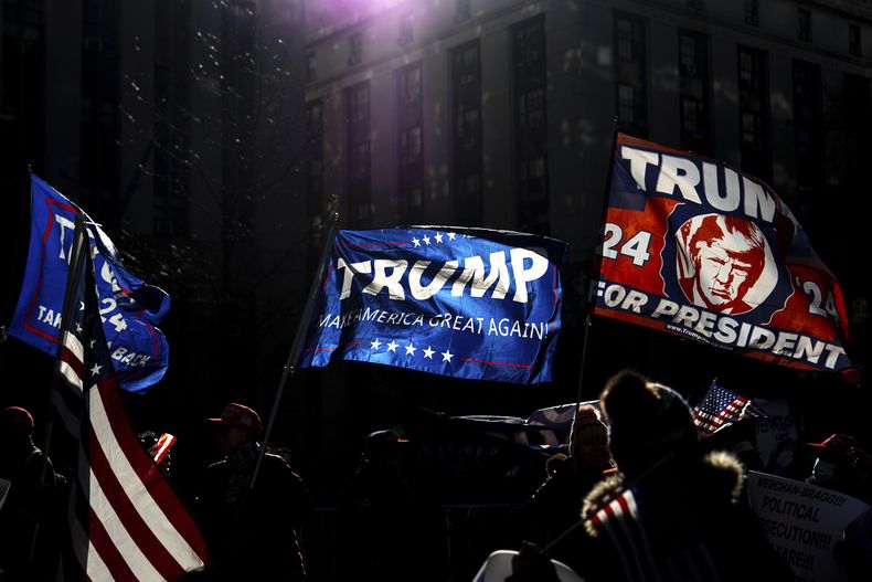 Manifestantes ondean banderas del presidente electo Donald Trump afuera de una corte en Manhattan luego de su sentencia en el caso de pagos a una actriz porno para mantener su silencio, el viernes 10 de enero de 2025, en Nueva York. (AP Foto/Julia Demaree Nikhinson)