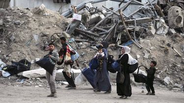 Palestinos evacúan después de que el ejército de Israel emitió una advertencia de evacuación para varias escuelas y un hospital en el vecindario de Rimal, el miércoles 14 de mayo de 2025, en Ciudad de Gaza. (AP Foto/Jehad Alshrafi)