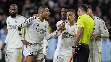 Kylian Mbappé, centro, del Real Madrid, habla con un árbitro asistente después de un tiro penal de Julián Álvarez, del Atlético de Madrid, durante una tanda de penaltis al final del partido de vuelta de los octavos de final de la Liga de Campeones entre el Atlético de Madrid y el Real Madrid en el estadio Metropolitano en Madrid, España, el miércoles 12 de marzo de 2025. (AP Foto/Bernat Armangue)