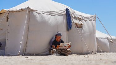 Un yemení desplazado lee un diario en el campamento de Al-Firdaws, en Ras Imran, en las afueras de Adén, Yemen, el 5 de octubre de 2026. (AP Foto/Abdulnasser Alseddik)
