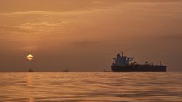 El sol sale tras varios petroleros fondeados en el estrecho de Ormuz en la costa de la isla de Queshm, Irán, el sábado 18 de abril de 2026. (AP Foto/Asghar Besharati)