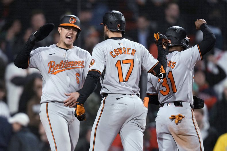 Colton Cowser (centro), de los Orioles de Baltimore, festeja luego de batear un jonrón de tres carreras en el juego del jueves 11 de abril de 2024 ante los Medias Rojas de Boston (AP Foto/Charles Krupa)