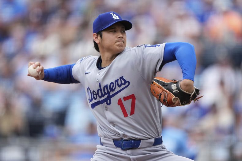 El lanzador abridor de los Dodgers de Los Ángeles, Shohei Ohtani, lanza durante la primera entrada de un partido de béisbol contra los Reales de Kansas City, el sábado 28 de junio de 2025, en Kansas City, Misuri. (AP Photo/Charlie Riedel)