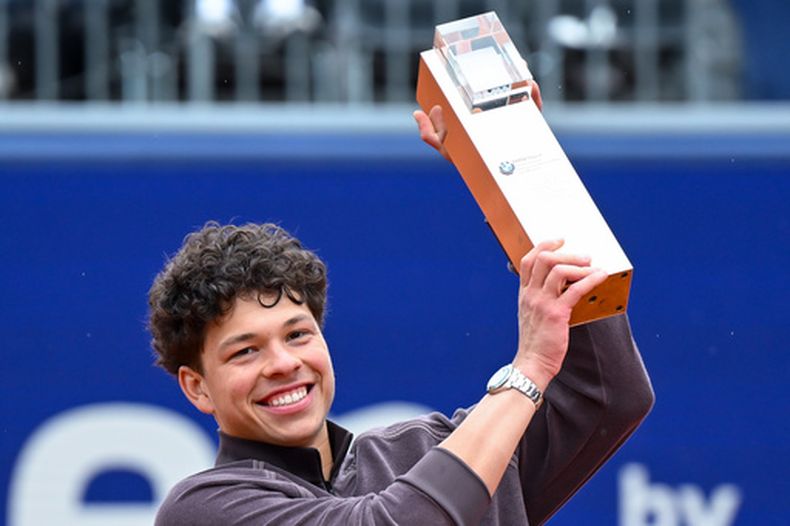 Ben Shelton celebra con el trofeo de campeón tras vencer a Flavio Cobolli en la final del Abierto de Múnich, el domingo 19 de abril de 2026.(Sven Hoppe/dpa vía AP)