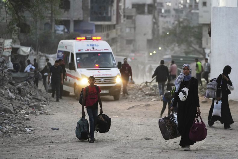 Palestinos se marchan con sus pertenencias tras la orden israelí para evacuar varias escuelas y un hospital en el vecindario de Rimal, en la Ciudad de Gaza, el 14 de mayo de 2025. (AP Foto/Jehad Alshrafi)