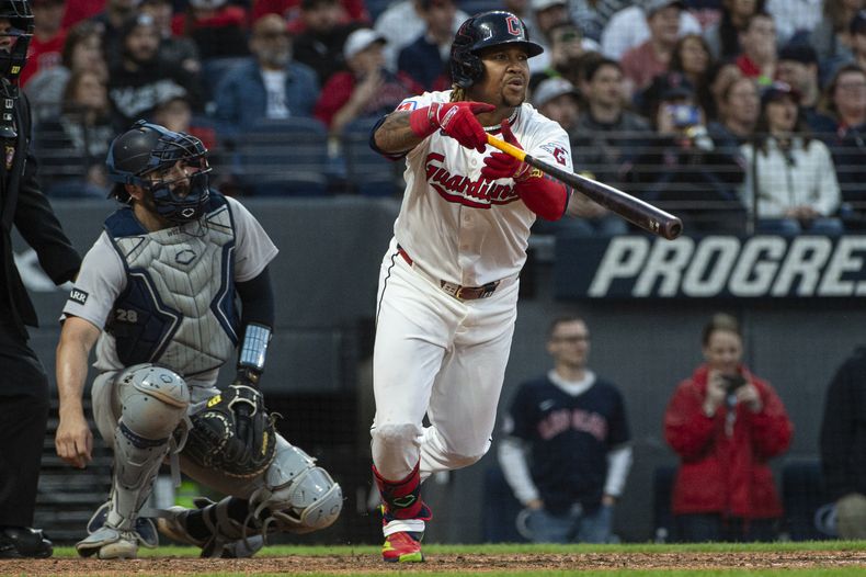 José Ramírez, derecha, de los Guardianes de Cleveland, observa su doblete productor frente al abridor de los Yankees de Nueva York, Clarke Schmidt, durante la sexta entrada del juego de béisbol de Grandes Ligas, el lunes 21 de abril de 2025, en Cleveland. (AP Foto/Phil Long)
