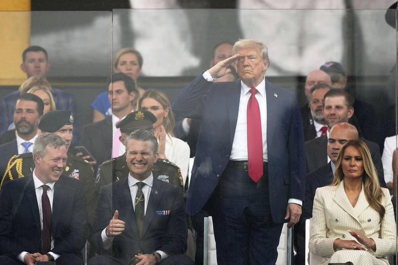 El presidente de EEUU, Donald Trump, saluda mientras asiste a un desfile militar conmemorativo del 250mo aniversario del Ejército, que coincide con su 79no cumpleaños, el sábado 14 de junio de 2025, en Washington, en presencia del secretario del Ejército Daniel Driscoll, el secretario de Defensa Pete Hegseth y la primera dama Melania Trump. (AP Foto/Julia Demaree Nikhinson)