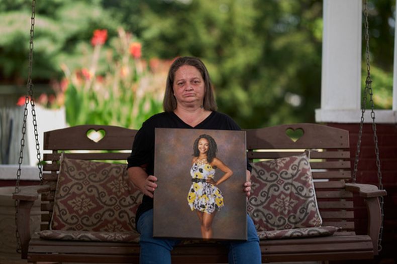 Christy Spivey con un retrato de su hija Tasia Fortune, en Marion, Kentucky, el 8 de septiembre del 2026. (AP foto/George Walker IV)