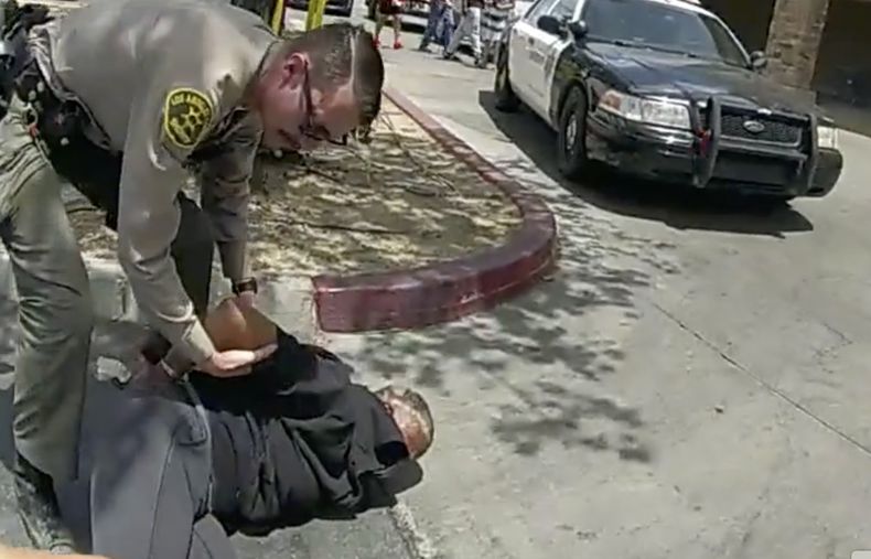 Imagen tomada de una cámara corporal policial y suministrada por el Departamento de Policía de Los Ángeles el 24 de junio del 2023, en que se ve a agentes arrestando a una pareja en el estacionamiento de un supermercado en Lancaster, California. (Departamento de Policía de Los Ángeles via AP)
