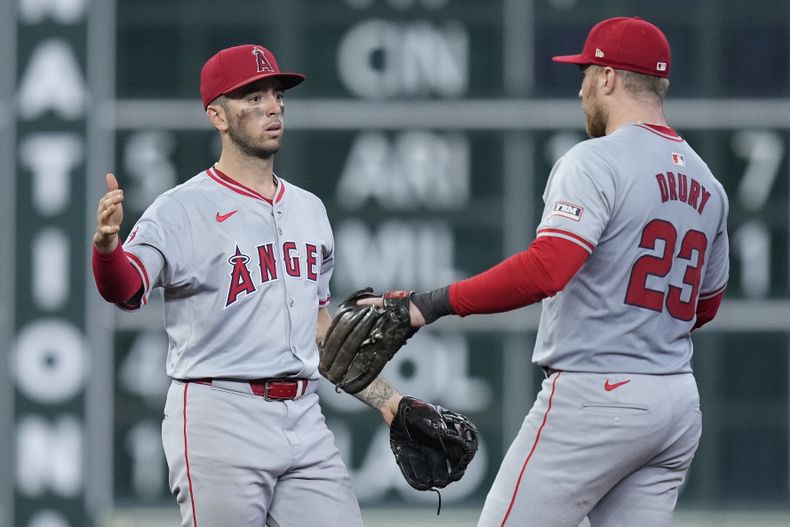 El campocorto de los Angelinos de Los Ángeles, Zach Neto, a la izquierda, y el primera base Brandon Drury (23), celebran después de vencer a los Astros de Houston, el domingo 22 de septiembre de 2024, en Houston. (AP Foto/Kevin M. Cox)