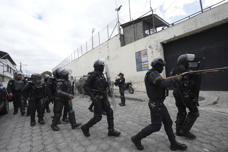 Policías y soldados se preparan para ingresar a la prisión El Inca donde se registran disturbios, en Quito, Ecuador, el lunes 8 de enero de 2024. El motín se produce un día después de que las autoridades ecuatorianas informaran que en otra prisión situada en la ciudad de Guayaquil el líder de la pandilla Los Choneros, Adolfo Macías, alias Fito, había desaparecido. Hace una década Fito huyó de otra instalación carcelaria. (Foto AP/Dolores Ochoa)