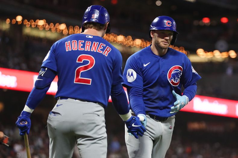 Ian Happ, derecha, de los Cachorros de Chicago, celebra su cuadrangular solitario con su compañero Nico Hoerner (2) durante la quinta entrada del juego de béisbol de Grandes Ligas del sábado 13 de junio de 2026, en San Francisco, California. (AP Foto/Scott Marshall)