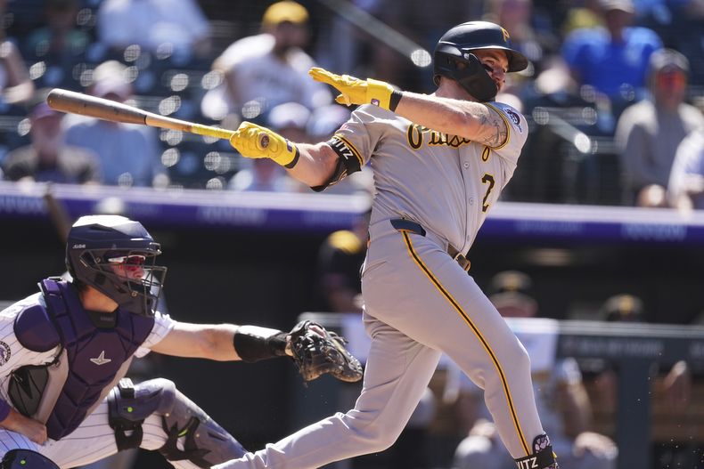 Spencer Horwitz de los Piratas de Pittsburgh pega un batazo en la octava entrada frente al catcher de los Rockies de Colorado Hunter Goodman el domingo 3 de agosto del 2025. (AP Foto/David Zalubowski)