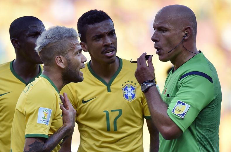 El &aacute;rbitro ingl&eacute;s Howard Webb, derecha, escucha al jugador de Brasil, Dani Alves, en un partido por el Mundial entre Brasil y Chile el 28 de junio de 2014 en Belo Horizonte, Brasil. (AP Photo/Martin Meissner/ File)
