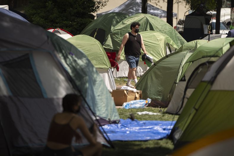 ARCHIVO - Una persona camina por un campamento establecido por estudiantes que protestaban contra la guerra entre Israel y Hamás en la Universidad George Washington, el martes 30 de abril de 2024, en Washington. (AP Foto/Mark Schiefelbein, archivo)