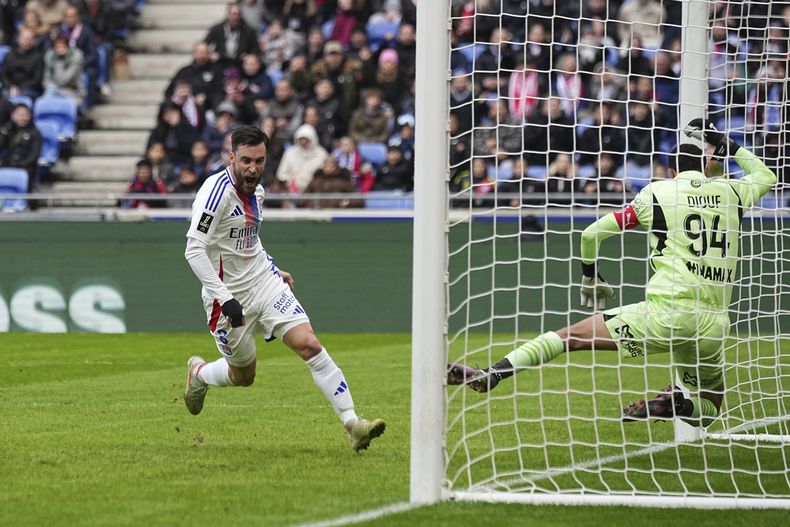 Nicolás Tagliafico (izquierda) tras anotar el primer gol de Lyon ante Reims en la liga francesa, el domingo 9 de febrero de 2025. (AP Foto/Laurent Cipriani)