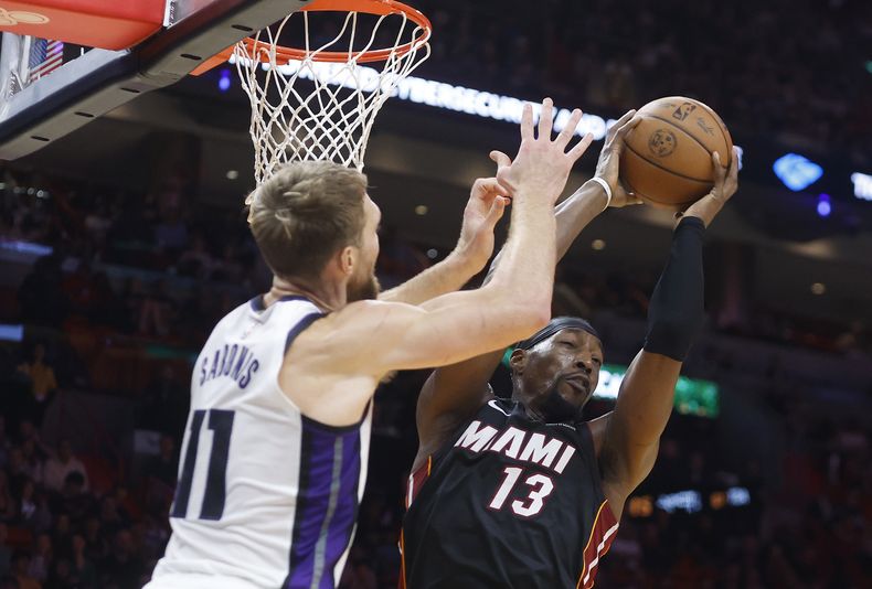 El pívot del Heat de Miami, Bam Adebayo (13), captura un rebote sobre el alero de los Kings de Sacramento, Domantas Sabonis (11), durante la primera mitad el lunes 4 de noviembre de 2024. (AP Foto/Rhona Wise)