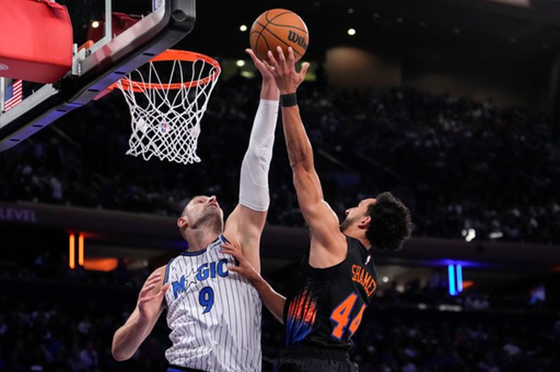El pívot del Magic de Orlando, Nikola Vucevic (9), bloquea el tiro del guardia de los Knicks de Nueva York, Landry Shamet (44), durante la primera mitad de un partido de básquetbol de la NBA, el domingo 25 de octubre de 2026, en Nueva York. (Foto AP/Yuki Iwamura)