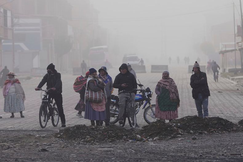 Residentes observan a la policía retirar las barricadas levantadas por manifestantes antigubernamentales en una carretera, el sábado 23 de mayo de 2026, en El Alto, Bolivia. (AP Foto/Juan Karita)