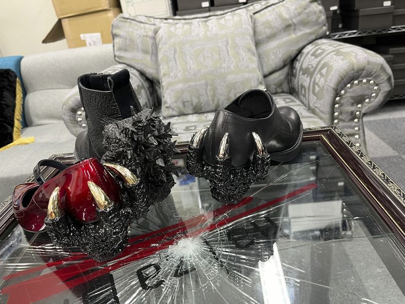 Zapatos de Godzilla del diseñador japonés Ryosuke Matsui, en una mesa igualmente diseñada por Matsui, durante una entrevista con The Associated Press en las oficinas de su empresa a las afueras de Tokio el viernes 22 de marzo de 2024. Matsui describió su alegría al ver al equipo de Godzilla Minus One con sus creaciones en la alfombra roja de los Oscar. (Foto AP/Yuri Kageyama)