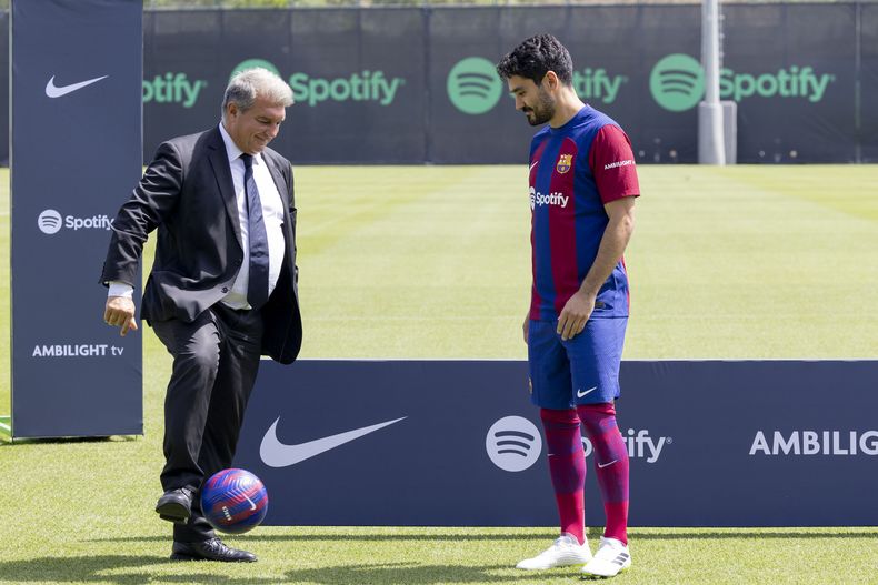 El presidente del Barcelona Joan Laporta patea el balón con el recién firmado Ilkay Gundogan durante una sesión de entrenamiento el lunes 17 de julio del 2023. (AP Foto/Joan Monfort)