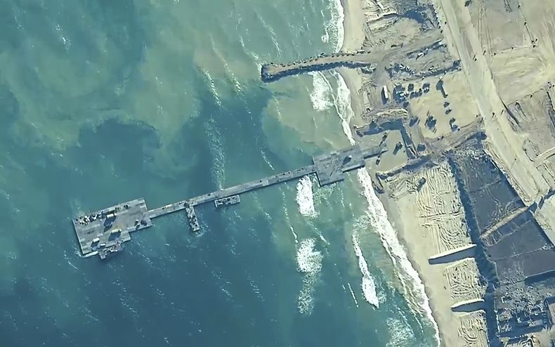 ARCHIVO - La imagen facilitada por el Mando Central de Estados Unidos muestra a soldados del Ejército estadounidense asignados a la 7ª Brigada de Transporte (Expedicionaria), marineros de la Armada estadounidense asignados al Batallón de Construcción Anfibia 1 y Fuerzas de Defensa de Israel colocando el Muelle Trident en la costa de la Franja de Gaza el 16 de mayo de 2024. (U.S. Central Command via AP)