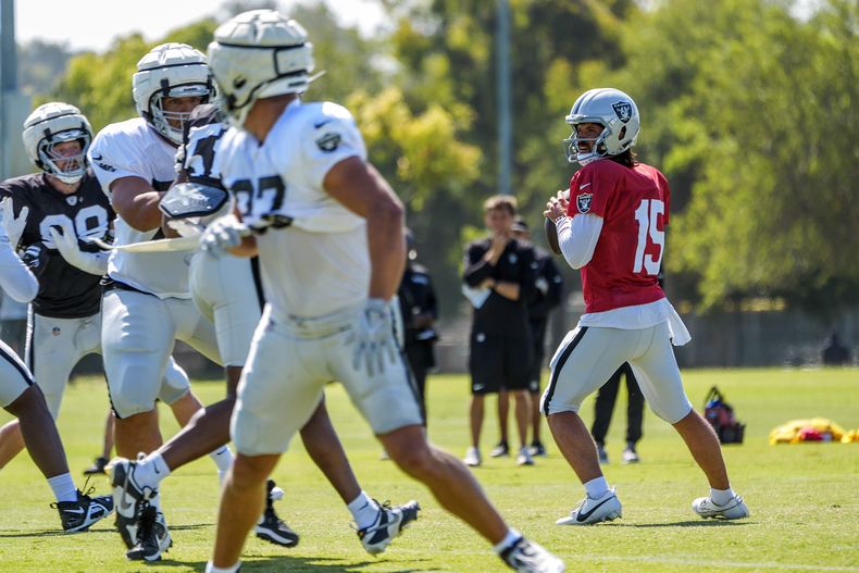 El quarterback de los Raiders de Las Vegas, Gardner Minshew (15) mira a quien lanzar durante el campamento de entrenamiento de fútbol americano de la NFL, en el Complejo Deportivo Jack R. Hammett en Costa Mesa, California, el martes 30 de junio de 2024. (AP Foto/Damian Dovarganes)