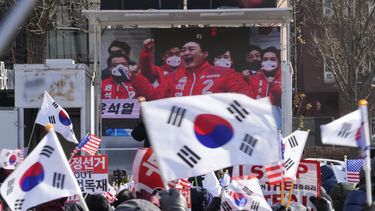 Una pantalla de televisión muestra una imagen de archivo del presidente de Corea del Sur, Yoon Suk Yeol, durante una marcha de partidarios del impugnado presidente para oponerse a su destitución cerca de la residencia presidencial en Seúl, Corea del Sur, el martes 7 de enero de 2025. (AP Foto/Ahn Young-joon)