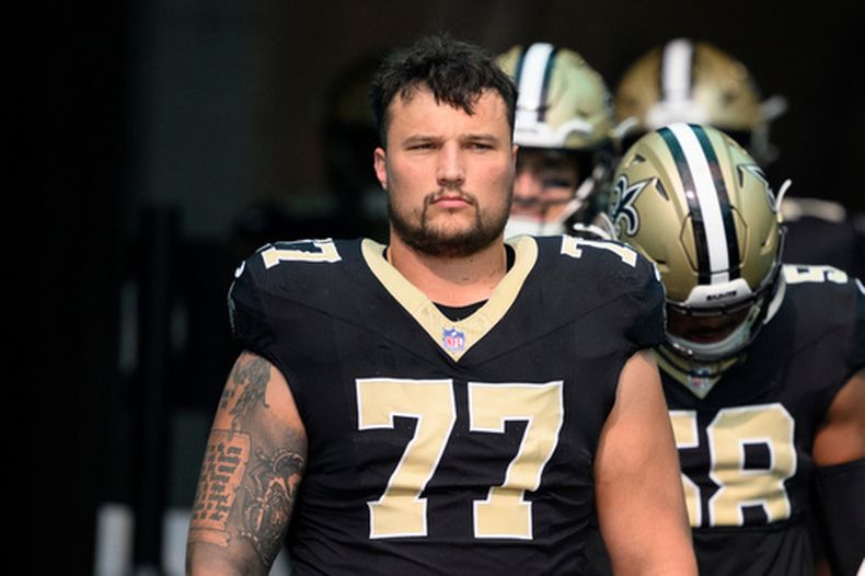 ARCHIVO - Dillon Radunz (77), liniero ofensivo de los Saints de Nueva Orleans, se prepara para caminar rumbo al campo de juego previo a un partido contra los Dolphins de Miami, el 30 de noviembre de 2025, en Miami Gardens, Florida. (AP Foto/Doug Murray, Archivo)