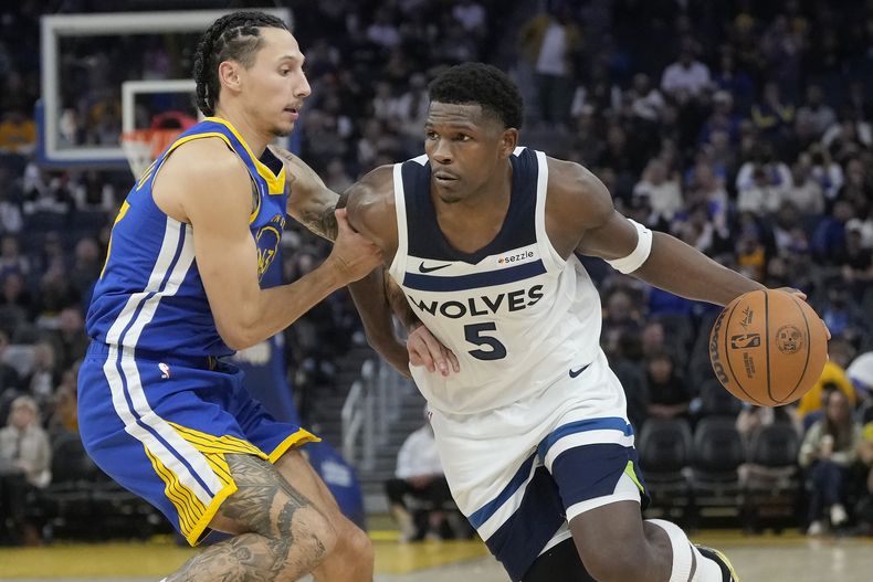 Anthony Edwards (5), de los Timberwolves de Minnesota, lleva el balón hacia la canasta con la presión defensiva de Lindy Waters III, de los Warriors de Golden Sate, durante la segunda mitad del juego de baloncesto de la NBA, el viernes 6 de diciembre de 2024, en San Francisco, Friday. (AP Foto/Jeff Chiu)