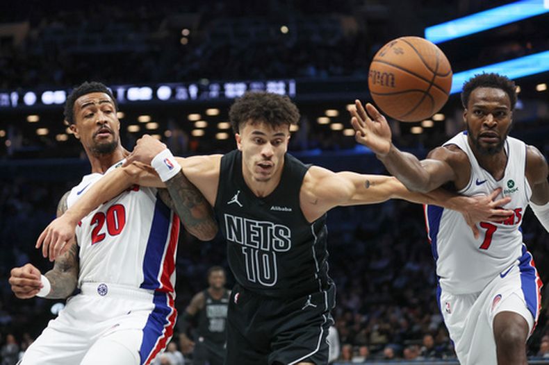 Paul Reed, derecha, de los Pistons de Detroit, Nolan Traore (10), de los Nets de Brooklyn, y John Collins (20), de los Pistons de Detroit, buscan recuperar un balón suelto durante la segunda mitad del juego de baloncesto de la Copa NBA, el viernes 30 de octubre de 2026, en Nueva York. (AP Foto/Heather Khalifa)